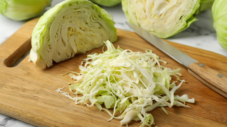 Shredded cabbage on wooden cutting board