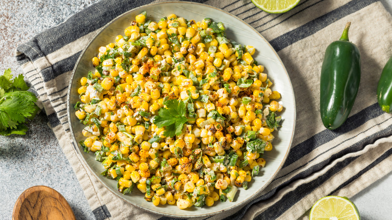 Esquites in bowl surrounded by ingredients