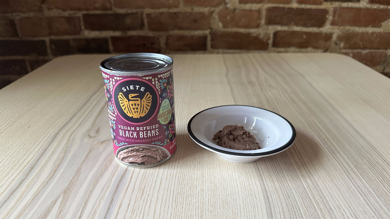 Siete refried black beans in small white bowl