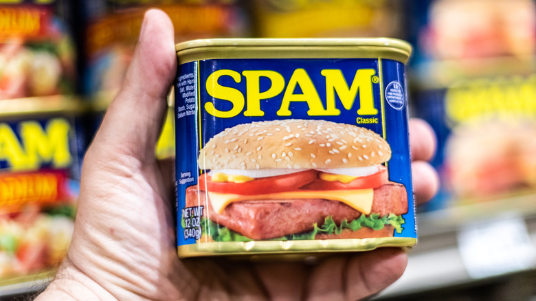 person holding can of Spam