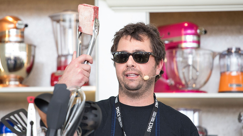 Jon Shook holding meat with tongs