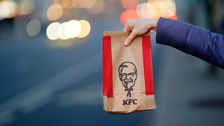 hand holding up KFC takeout bag