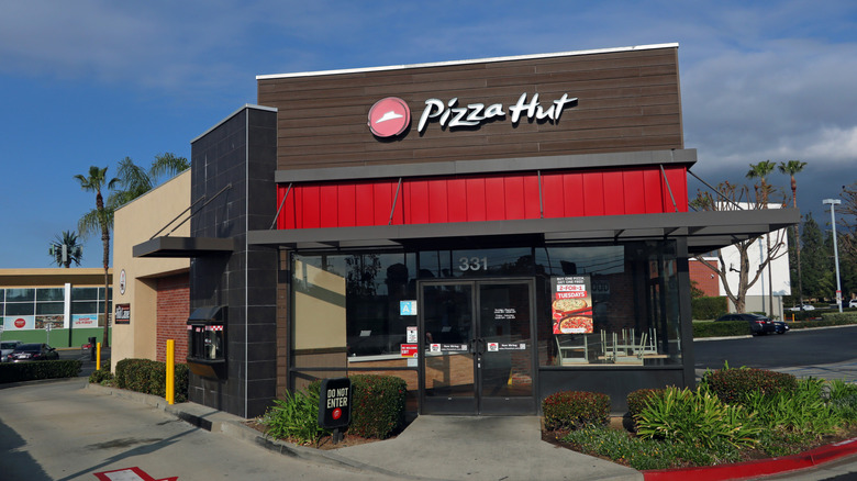 front of pizza hut restaurant in front of blue sky with clouds
