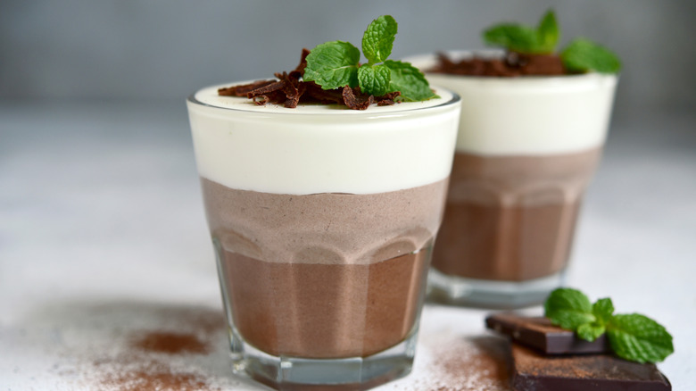 Chocolate mousse desserts in glass cups with fresh mint and chocolate