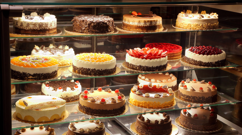 A wide variety of cakes in a bakery case