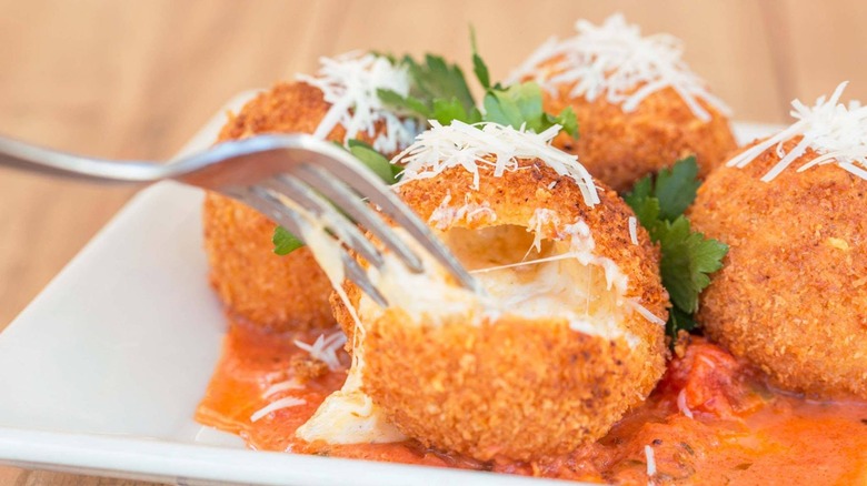 Golden fried macaroni and cheese balls on a white plate