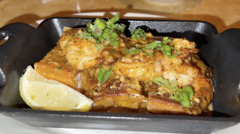 Cajun shrimp with a slice of lemon in a cast iron dish