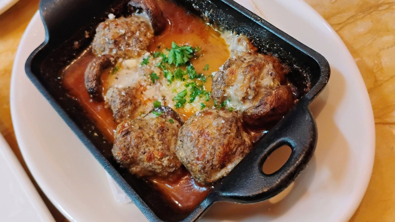 Stuffed mushrooms in a cast iron dish on a white serving plate