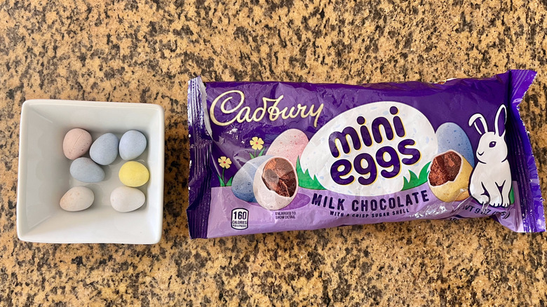 Cadbury Mini Eggs Milk Chocolates inside a dish next to a wrapper on countertop