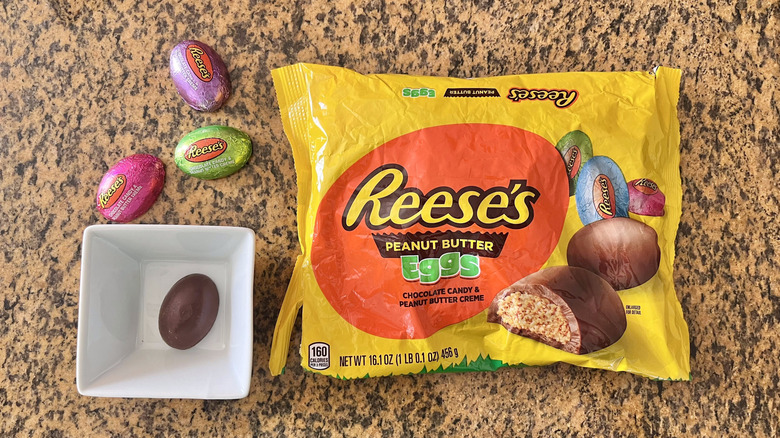 Reese's Milk Chocolate Peanut Butter Eggs on countertop with one in a dish and wrapped ones on the counter
