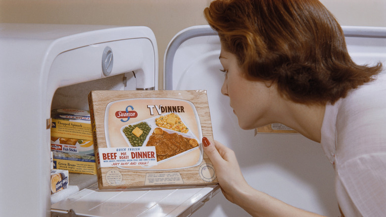 1960s woman grabs TV dinner from freezer