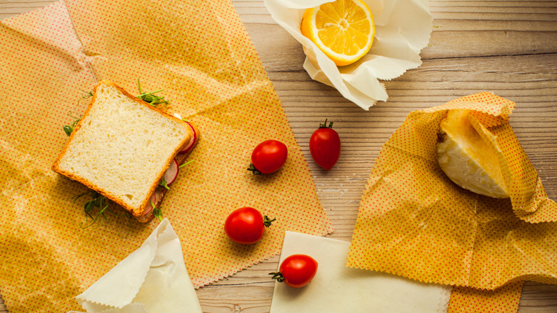 Sandwich and fruits in unwrapped beeswax wrappers on table