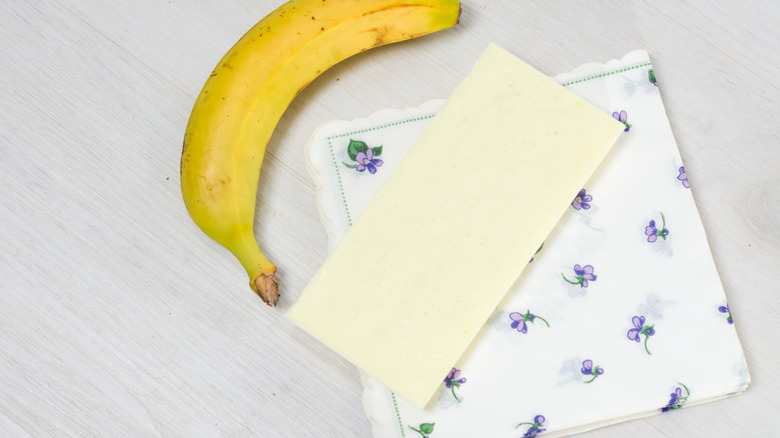 Folded beeswax wrap with napkin and banana on table