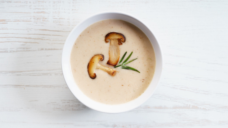 Mushroom soup with brown mushroom on white table