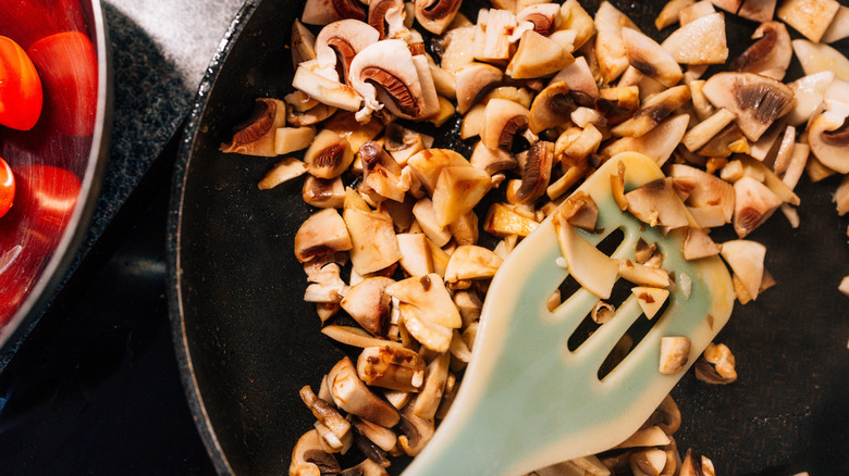 close up of mushrooms and spatula in black pan