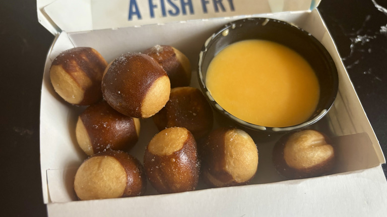 Pretzel bites with cheese sauce in container