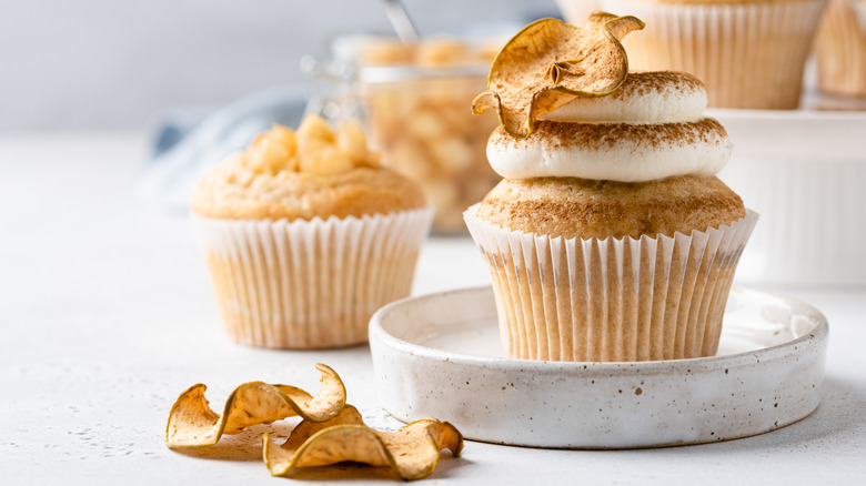 Cupcake with a slice of dried apple on top of it, sprinkled with lots of cinnamon