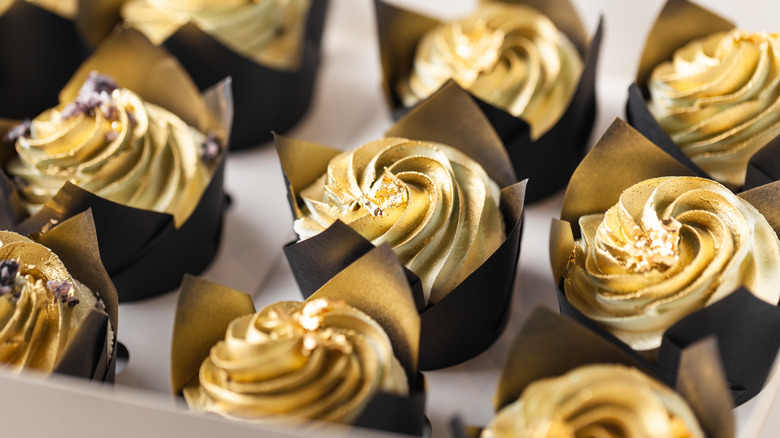 selection of gold metallic cupcakes in paper cups