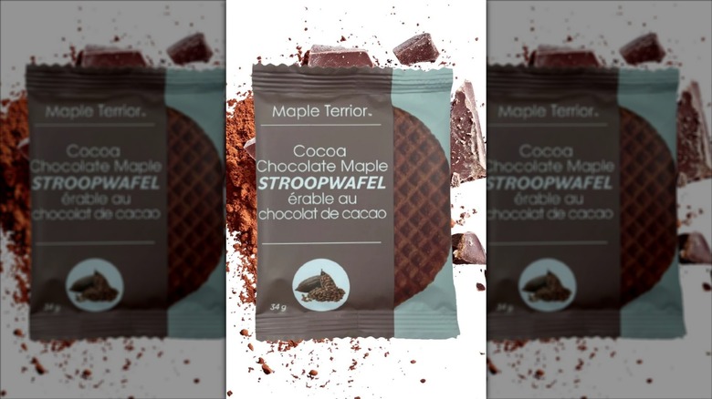 Single package containing a Maple Terrior cocoa chocolate maple stroopwafel with chocolate in the background