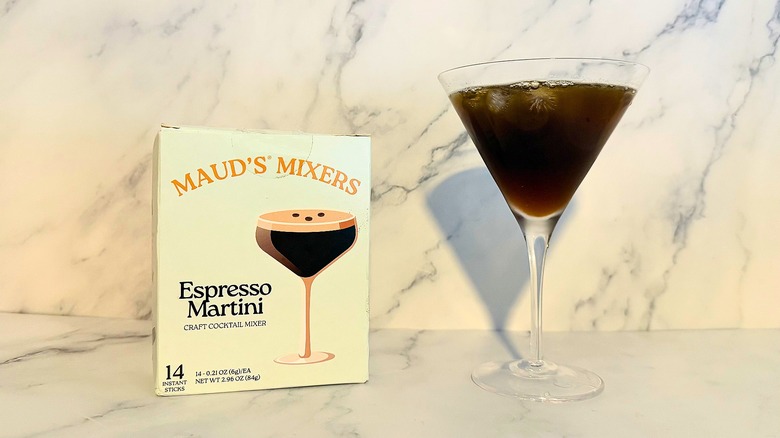 Box of Maud's Mixers espresso martini mix next to espresso martini in glass on marble surface