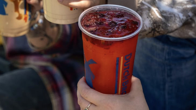 woman holding cold berry drink