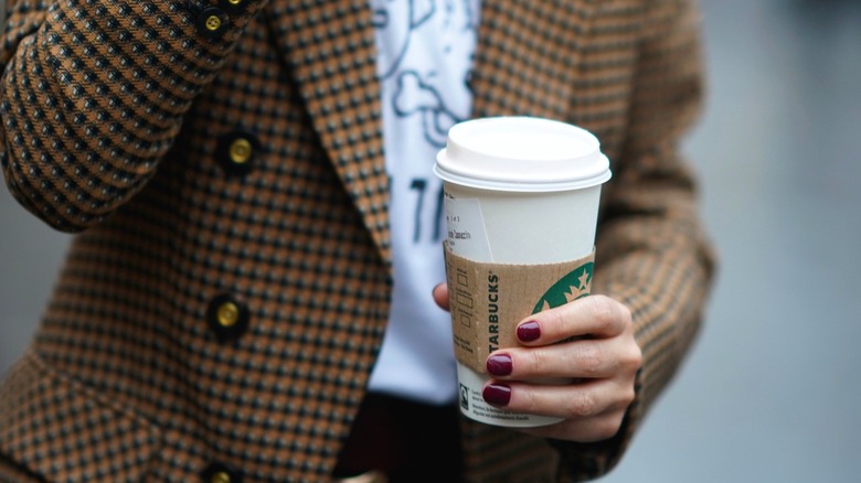 woman in jacket holding coffee