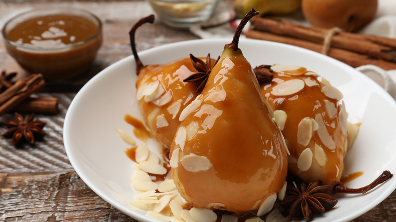 plate of cooked pears with caramel sauce and almonds