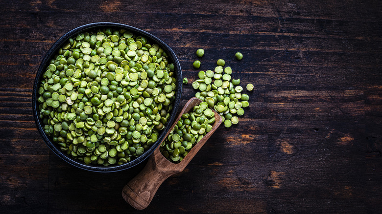 overhead view of green split peas in wooden scoop and bowl