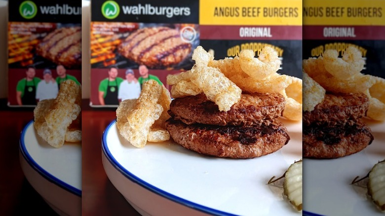 double burgers topped with pork rinds in front of wahlburgers angus beef burger box