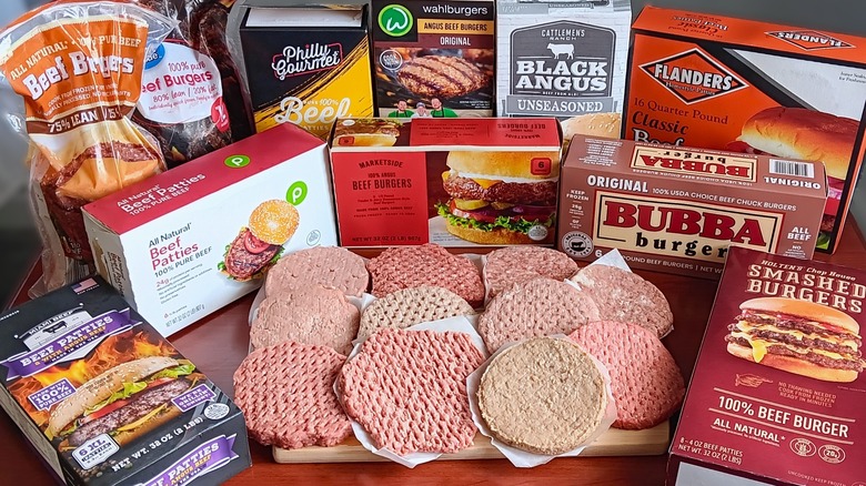 11 brands of frozen beef burgers surrounding a cutting board with one raw patty from each brand