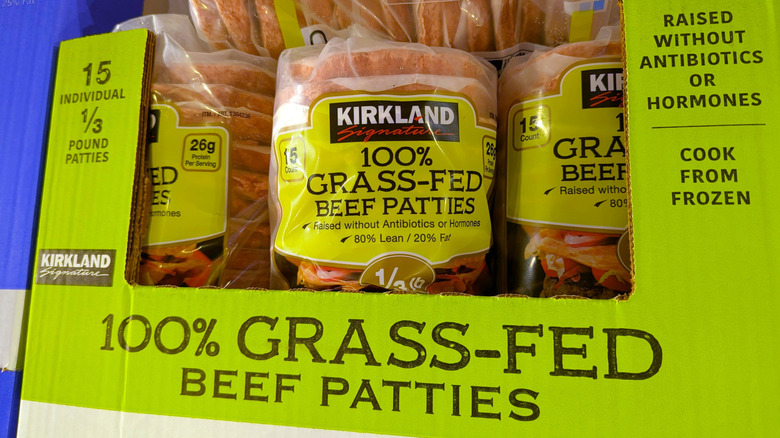 Packages of Costco brand Kirkland Signature grass-fed beef patties sitting inside light green cardboard box