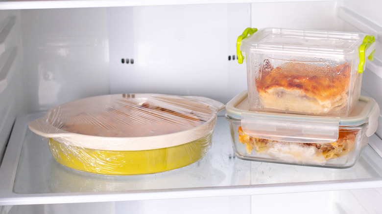 Food in glass dishes on refrigerator shelf with condensation inside