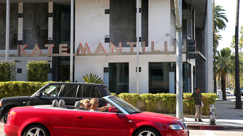 The front of Kate Mantilini Restaurant with cars driving past