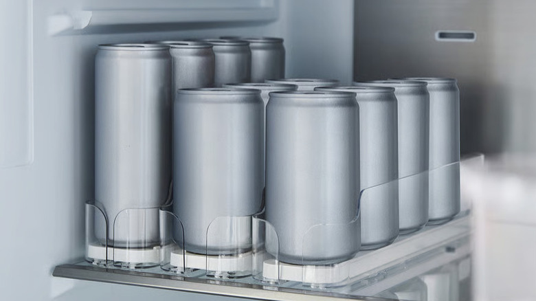 Plain renderings of soda cans being stored in a drink organizer inside of a refrigerator