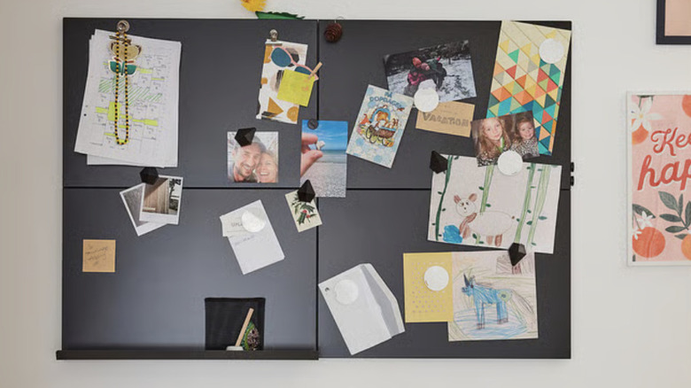 Magnetic memo board hung on the wall and filled with pictures, cards, and children's drawings