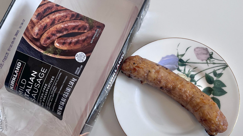 Kirkland Signature mild Italian sausage on a plate and a pack of sausages on the side