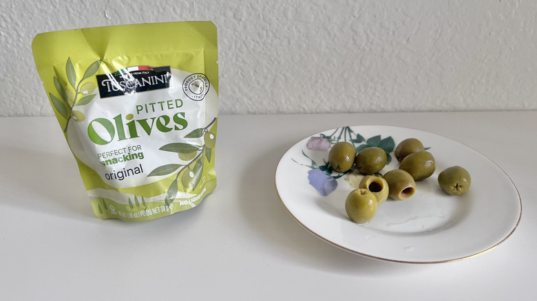 Tuscanini pitted olives package with some olives on a plate