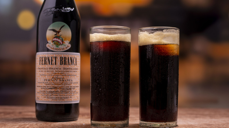 Fernet branca bottle with two glasses of fernet and cola.