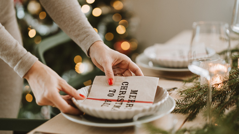 Woman setting the table for a Christmas dinner