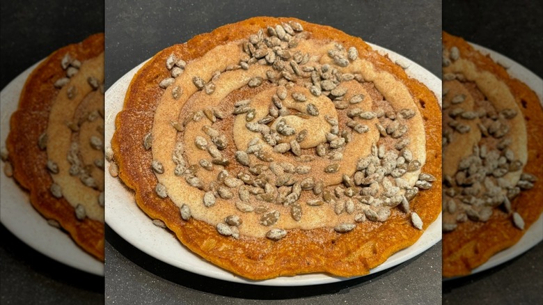 Big pumpkin cinnamon swirl pancake with seeds on white plate from Herm's Inn