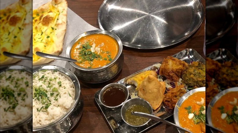 Spread of classic Indian dishes on wooden table at Tandoori Oven in Logan Utah