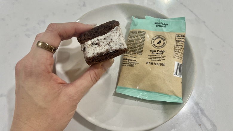 Hand holding chomps size Mint Fudge Brownie Nightingale ice cream sandwich.