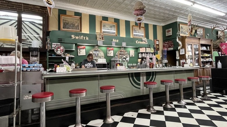 Soda fountain counter with red stools and checkered floor