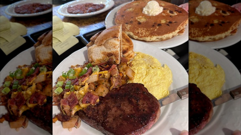 Plates of food at diner including pancakes and steak and eggs.