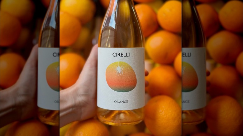 bottle of orange wine surrounded by oranges