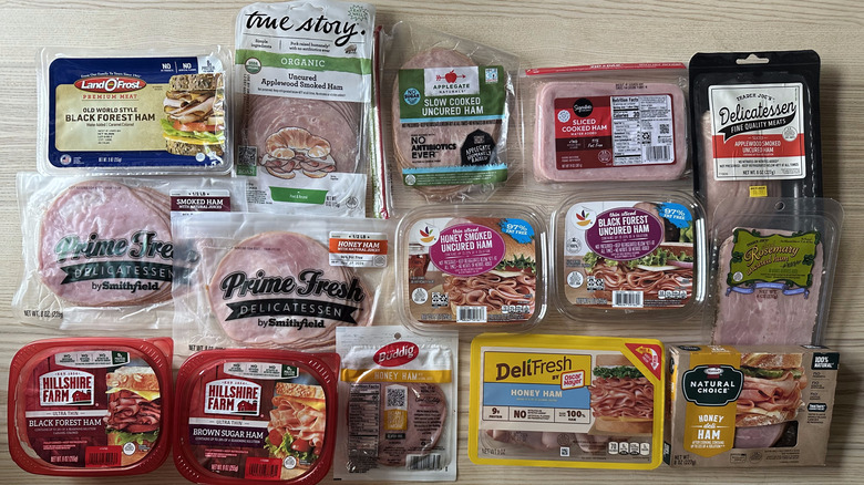 Packages of sliced deli ham arranged on wooden table