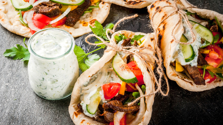 Greek pita stuffed with meat, cucumber, tomato, onion, and sauce, tied with twine