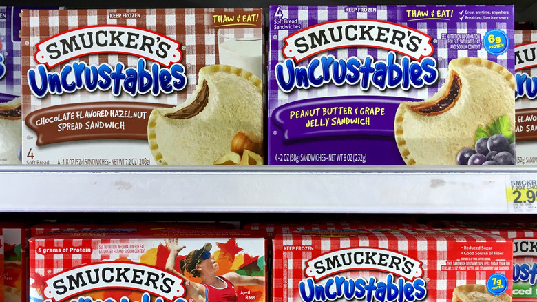 A supermarket display of Smuckers Uncrustable sandwiches in chocolate hazelnut spread flavor and peanut butter and grape jelly flavor