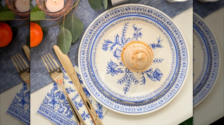 The Coterie French Toile paper plates set with a matching napkin on a styled table