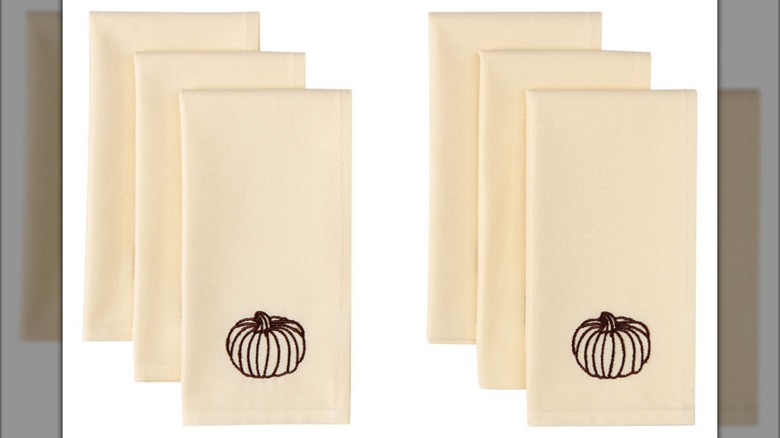 Six napkins with a small pumpkin at the bottom